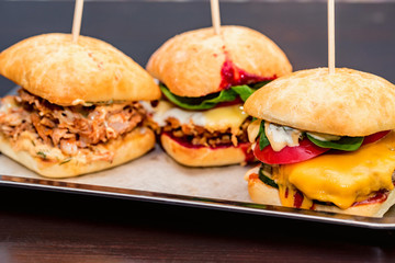 Close up three tasty burgers with different filling served on tray