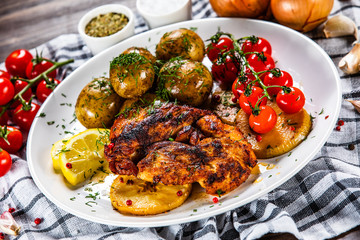 Grilled chicken fillet and vegetables on white plate