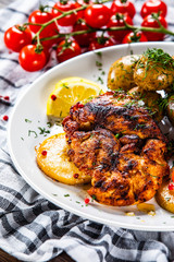 Grilled chicken fillet and vegetables on white plate