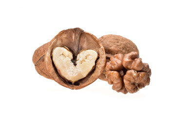Still life of whole and chopped walnuts with pulp in the form of a heart on a neutral white background close-up