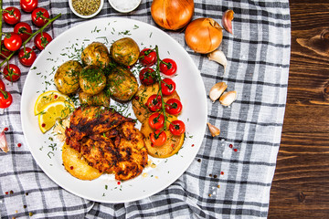 Grilled chicken fillet and vegetables on white plate