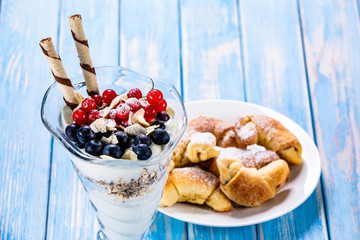 Yogurt with fruits on wooden background