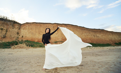 Fototapeta na wymiar Ballet woman Dancer at Sunset beach. Classical dance in white chiffon skirt