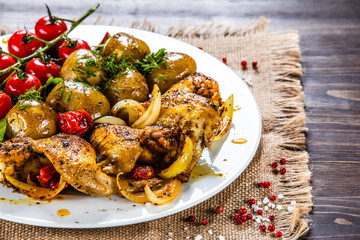 Roast chicken wings, baked potatoes and vegetables