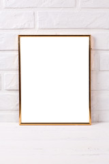 Empty  golden  frame mockup  with copy space  near by brick white wall.