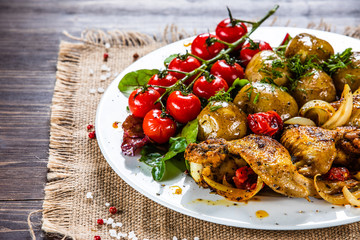 Roast chicken wings, baked potatoes and vegetables