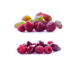 Pink berries isolated on white background. Ripe raspberries and grapes. Background of mix berries with copy space for text. Mix berries on white background. Berries isolated on white background.
