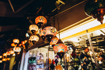 Obraz premium Shopping at the Grand Bazaar. Traditional Turkish lamps in the souvenir shop. Handmade glass mosaic at the Grand Bazaar. Nazar Bonjuk against the evil eye