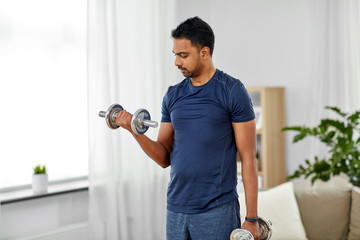 fitness, sport, weightlifting and bodybuilding concept - indian man exercising with dumbbells at...
