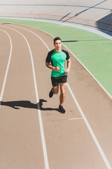 Obraz premium full length view of mixed race sportsman running at stadium