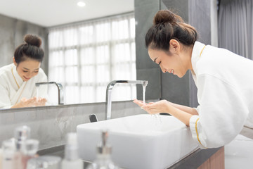 Portrait of beautiful Asian girl is washing her face.