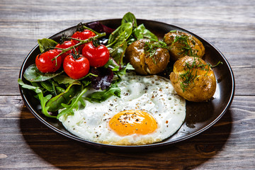 Fried egg, boiled potatoes and vegetables