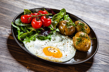 Fried egg, boiled potatoes and vegetables