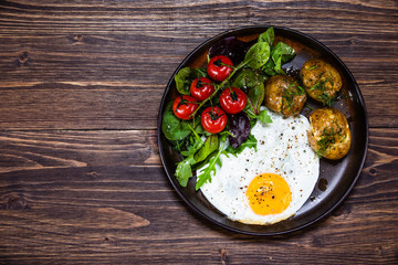 Fried egg, boiled potatoes and vegetables