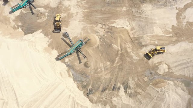 Aerial view loading bulldozer in open air quarry. Sand loading