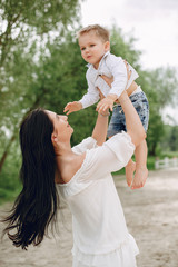 Fototapeta premium Family in a summer park. Mother in a white dress. Cute little boy