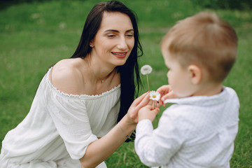 Family in a summer park. Mother in a white dress. Cute little boy