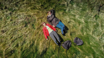 Two women lying at the edge of the cliff at the Irish west coast - aerial drone footage - travel photography