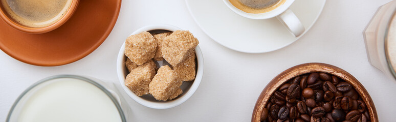 top view of coffee with milk and brown sugar on white background, panoramic shot