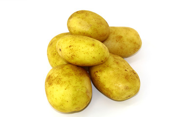 In the middle of the photo on a white background untreated young potatoes