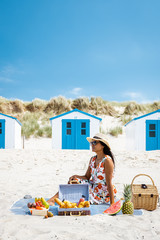 couple having lunch picnic on the beach with fruit bread and drinks, Texel netherlands