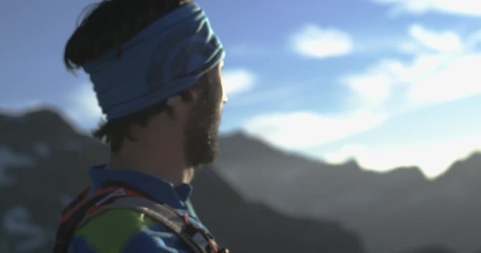Trail runner man running reaching mountain top peak goal looking horizon view.Portrait shot.Wild nature outdoors at sunrise or sunset backlit.Training activity,sport,effort,challenge,willpower concept