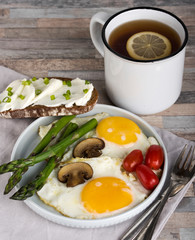 Breakfast. Scrambled eggs, asparagus, champignons, cherry tomatoes, sandwich