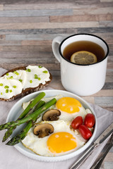 Breakfast. Scrambled eggs, asparagus, champignons, cherry tomatoes, sandwich