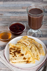 Breakfast. Pancakes, honey, strawberry jam, cream, dried apricots, nuts and hot chocolate or cocoa or coffee