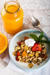 Breakfast. Muesli with milk or yogurt, nuts and strawberries, orange juice and orange