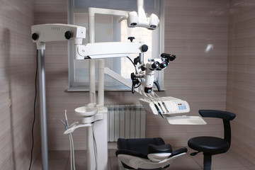Dental binocular microscope on the background of modern dentistry. Medical equipment. operating microscope. with rotary double dental microscope white cabinet working room
