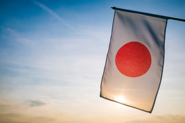 Japanese flag hanging outdoors in the still golden light of the rising sun in Tokyo, Japan