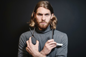 Portrait of hairdresser at black background isolated. Portrait of bearded man. Barber with scissors and straight razor, barber shop. Vintage barbershop, shaving. Beard macho man. Brutal guy.