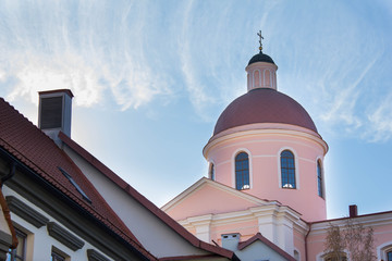 Pink tower of the cathedral in Vilnius, Lithuania. Dome against blue sky in a bright day light. Orthodox church and architecture building with the cross on the roof.  Christian religious traditions.