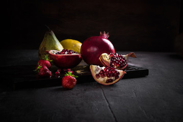 pomegranates and pears with other fruit bodegon with classic light on wood