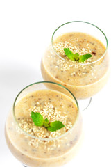 Healthy banana smoothie in glass with mint isolated on white background