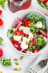 Salad with cherry tomatoes, radsh and mozzarella, lettuce mix
