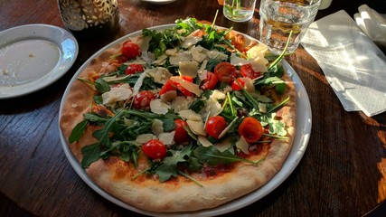 beatutiful pizza with rucola parmesan and cherry tomatoes