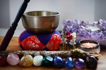 Healing crystals, fresh herbs, and tibetan singing bowl. Rainbow crystals on wood table, candles,...