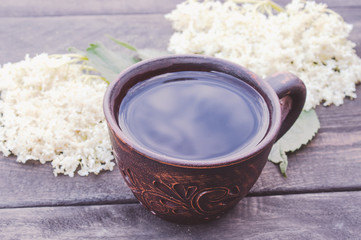 Fototapeta na wymiar a cup of Elderflower tea with fresh flowers