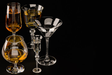 Strong alcoholic beverages, glasses and glasses, in the presence of whiskey, vodka, rum, tequila, brandy, cognac. on dark old background with selective focus