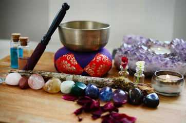Healing crystals, fresh herbs, and tibetan singing bowl. Rainbow crystals on wood table, candles, and singing bowl. Witches alter, bohemian decorations. Wiccan crystal grid, rainbow design. 