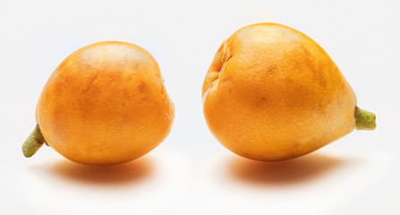 Two fresh loquats (medlars). Isolated on white background. Close-up.