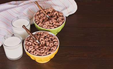 bowls of corn snacks and glasses of milk on the table. the morning Breakfast of corn puffs with milk.