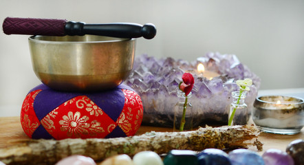 Healing crystals, fresh herbs, and tibetan singing bowl. Rainbow crystals on wood table, candles, and singing bowl. Witches alter, bohemian decorations. Wiccan crystal grid, rainbow design. 