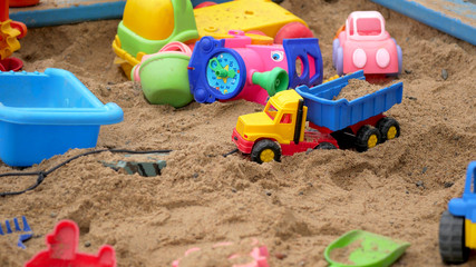 Fototapeta na wymiar Children's Sandbox. Set Of Colored Plastic Toys On The Sand, 