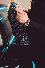 Cropped view of man holding hand of stylish young woman