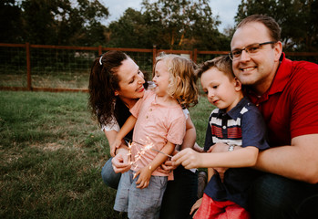 Happy family playing with sparkler fireworks together