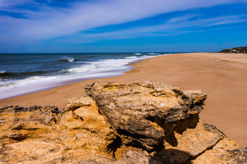 Fototapeta na wymiar rock on beach in Nazare on Atlantic coast with ocean wave