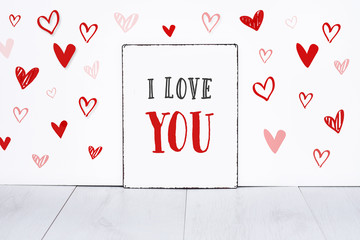 Text i love you on sign board with little hand drawn hearts on white background valentine’s day banner